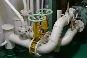 Engine room interior of a big ocean going ship with pipes, piping and valves