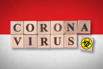 Indonesia flag background and wooden blocks with letters spelling CORONAVIRUS and quarantine symbol on it. Novel Coronavirus (2019-nCoV) concept for an outbreak occurs in Indonesia.