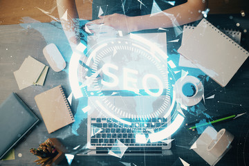 Multi exposure of woman's hands making notes with SEO icon. Concept of Search engine optimization
