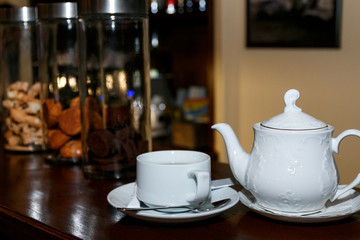cup of coffee and teapot on table in cafe