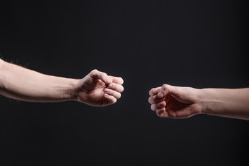 Men's hands on a dark background, show a game of stone, scissors, paper. The concept of...