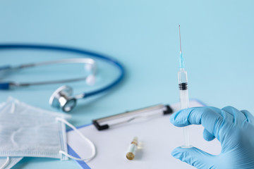 Medical concept on a blue background. Stethoscope, notepad, sheet of paper, pen, medical mask,...