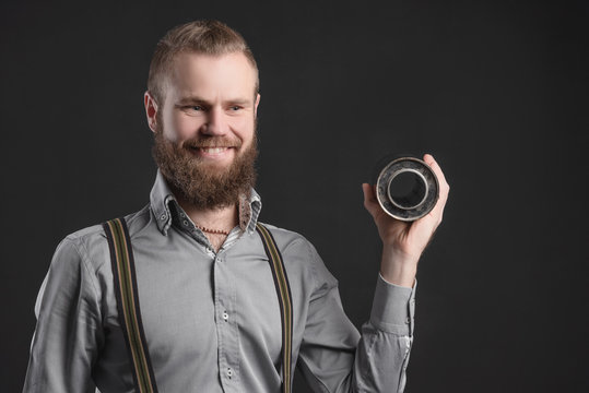 Handsome young man presents car parts on a gray background. The concept of sales and testing of goods