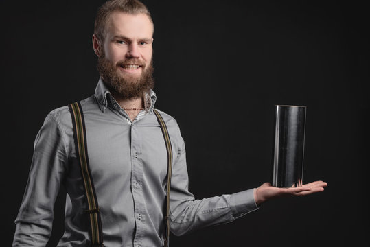 Handsome young man presents car parts on a gray background. The concept of sales and testing of goods