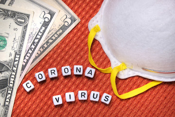 Text coronavirus word, white protective mask, american bank notes dollars on a fabric background.