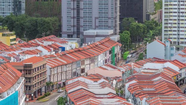 Aerial view of art deco shophouses with red roofs along Neil road in Chinatown area timelapse. Traffic on the street with intersection