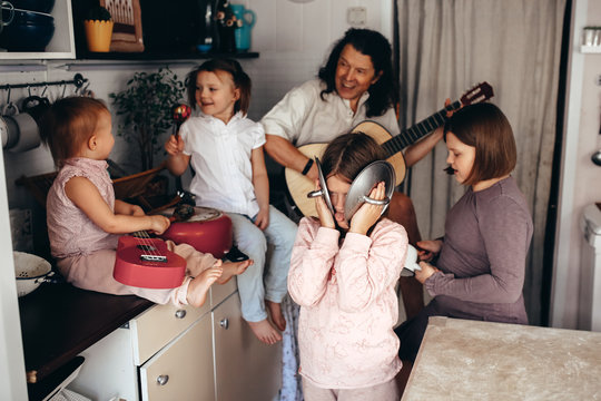 large family with 4 children plays music at home