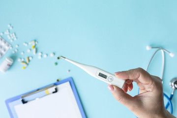 medical concept on a blue background. stethoscope, pills, tablet, notepad, sheet of paper, pen