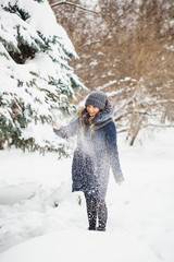 A girl of European appearance walks in the Park, forest, winter and snow, dressed in warm clothes, hat, jacket, scarf, rest, Hiking