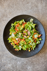 Vegetable salad with tuna on a black plate
