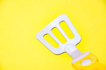 Toy tool for cooking. Ladle, slotted spoon, spatula for cooking on a yellow, blue, black background. Kitchen tools.  Copy Space