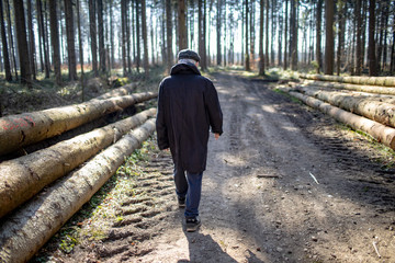 Älterer Mann Senior spaziert allein im Wald Social Distancing wegen COVID19-