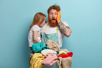 Overloaded father feels exhausted as plays with child and does laundry at home, has no spare time,...