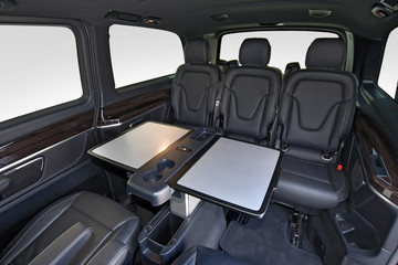 Interior of luxury van with comfortable leather seats and table - obrazy, fototapety, plakaty