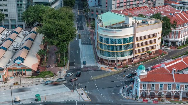 Aerial view of intersection and art deco shophouses with red roofs along Neil road in Chinatown area timelapse. Traffic on the street with crossroad and crossing