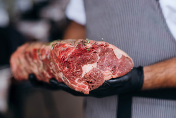Big fresh muscle beef meat. Hand holding a large piece of beef meat.