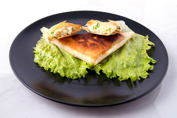 Pita triangles with cottage cheese, herbs, tomatoes on a black and white plate