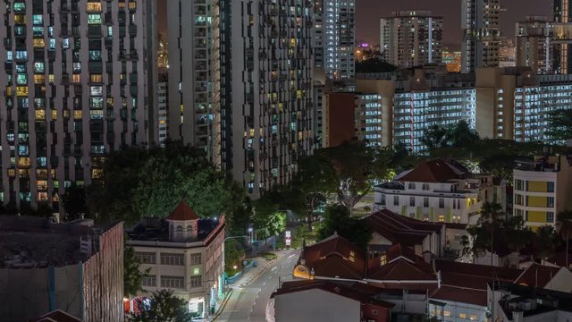 Aerial view of intersection and art deco shophouses with red roofs along Neil road in Chinatown area night timelapse. Traffic on the street with crossroad and crossing