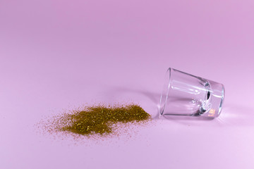 Tequila glass and glitter on pink background