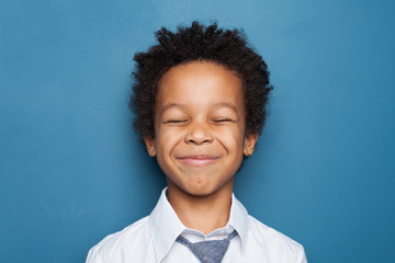 Laughing small black child boy student on blue background