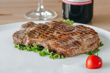 Meat steak and salad with a glass of red wine on a plate