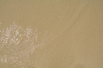 Soft water reaching the shore of the beach