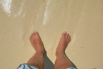 Fototapeta na wymiar Bare feet in the water on a caribbean beach