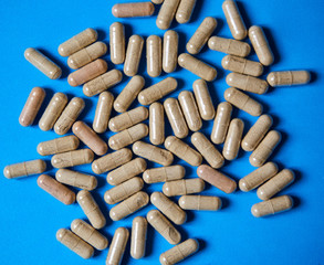 Tablets, vitamins, or medications are placed on a bright colored background.