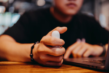 Close up man hold wireless earphone in charger box for battery