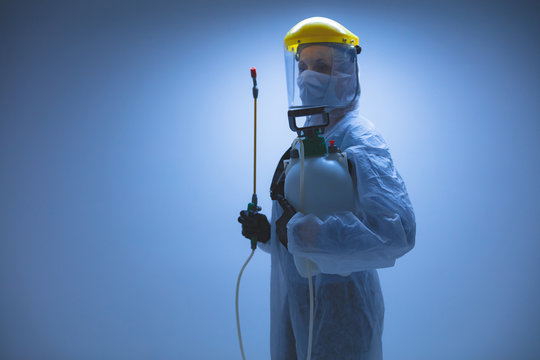 Scientist holding chemical sprayer for sterilization and decontamination of viruses, germs, pests, infectious diseases.
