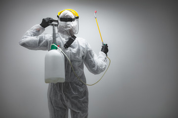 Scientist holding chemical sprayer for sterilization and decontamination of viruses, germs, pests,...