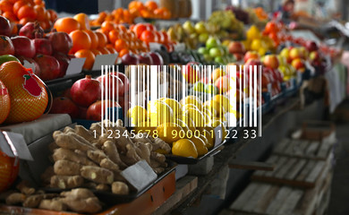 Barcode and tasty fresh fruits on counter at wholesale market
