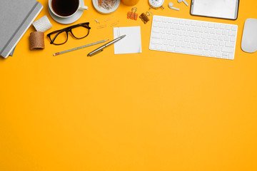 Flat lay composition with computer accessories and different office items on orange background....