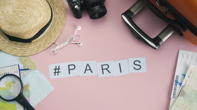 Top view hands laying on pink desk word PARIS