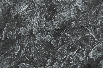 Texture of black rice paper with white streaks on it. Rice paper with creases cracks and spots. Textured paper background.