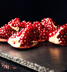 Pomegranate on a dark background. Pieces of pomegranate.