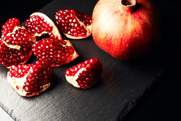Pomegranate on a dark background. Pieces of pomegranate.