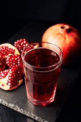 Pomegranate juice on a dark background. Summer drink. Pomegranate on a dark background.