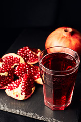 Pomegranate juice on a dark background. Summer drink. Pomegranate on a dark background.