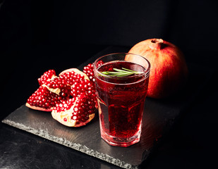 Pomegranate juice on a dark background. Summer drink. Pomegranate on a dark background.
