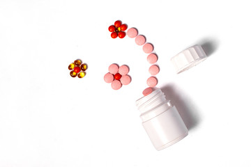 White plastic bottle with medicines and vitamines. tematic health. rose, yellow and red medicines.