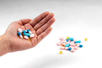 Colorfull medicine pills in men hand. blue, rose and yellow medicines and vitamins