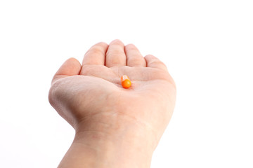 Orange pill in palm hand. medicines and vitamins