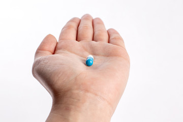 Blue and white pill in hand. medicines and vitamins