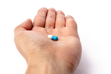 Blue and white pill in hand. medicines and vitamins