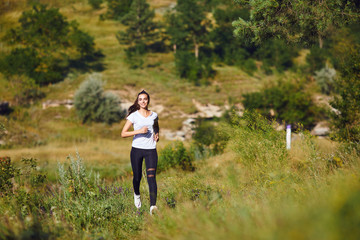 Young athletic girl runs on the nature.