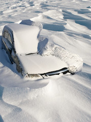 Car covered with snow in the winter snowfall