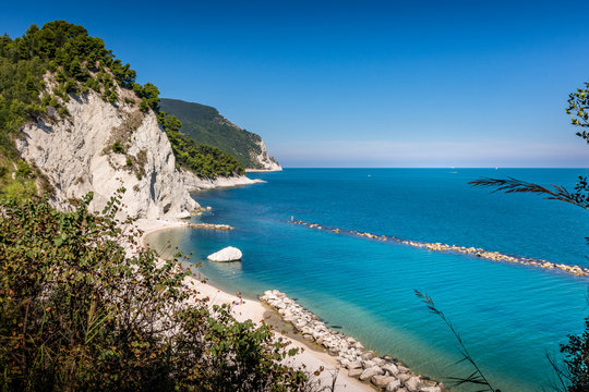Beach of Numana Alta, with the white cliffs and clear blue water of the adriatic in Summer