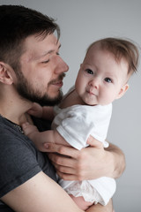 Man holding a newborn baby. Dad and baby. Close-up. Portrait of young smiling family with newborn on the hands. Happy family.