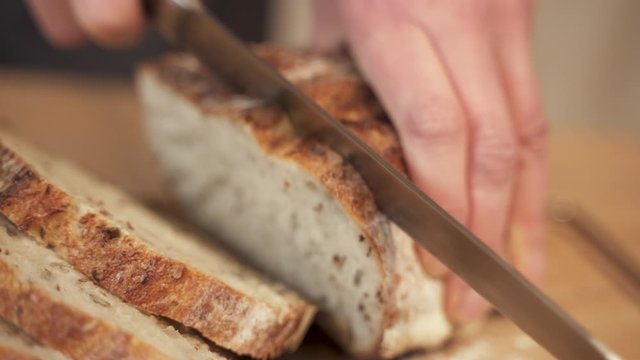 Closeup of cutting bread in slices